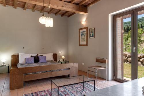 モンテカティーニ・ヴァル・ディ・チェーチナにあるHigh-quality Villa with private pool San Giuseppe Maestraleのベッドとガラスのテーブルのある寝室