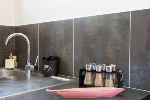 un comptoir de cuisine avec un évier et un plateau avec des épices dans l'établissement Maison à l'océan plage sud, à Lacanau