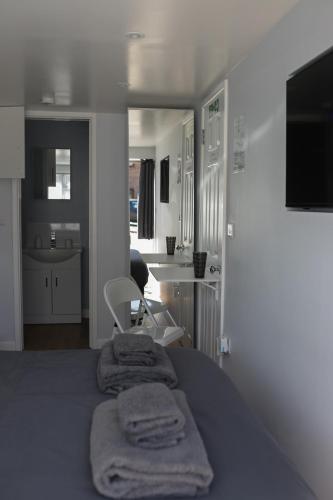 a bedroom with a bed with towels on it at The snug, Yapton, Arundel, West sussex in Yapton