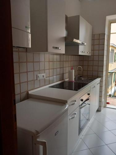 a kitchen with white cabinets and a sink at CASA DONATELLA a pochi passi dal mare in Levanto