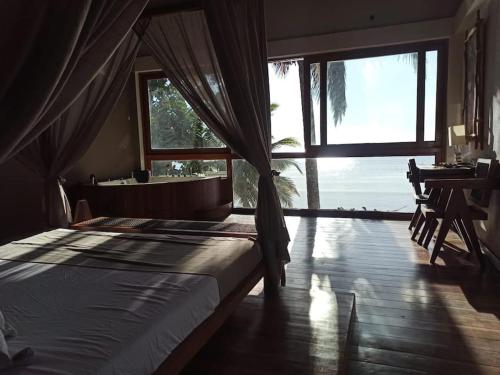 a bedroom with a bed and a tub and a window at La Spiaggia, tropical villa with private beach in Sainte Marie