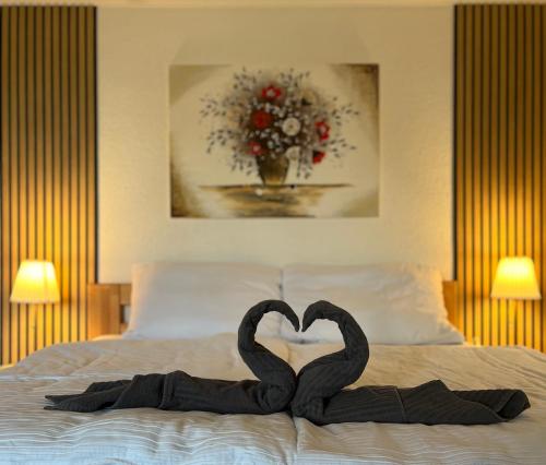 two black swans making a heart on a bed at PENZION Karin in Rýmařov