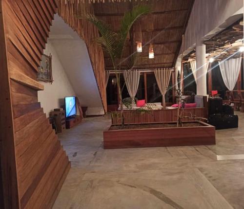 a large living room with a couch and a tv at La Spiaggia, tropical villa with private beach in Sainte Marie