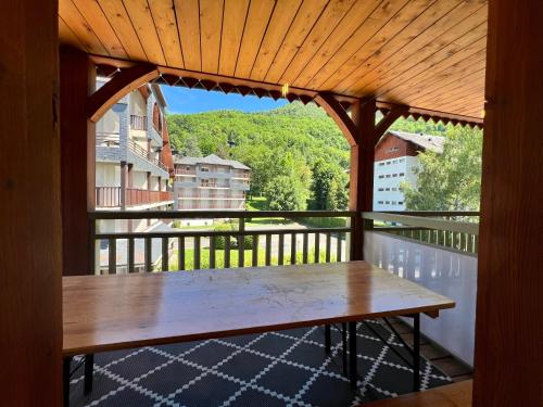 a porch with a wooden table on a balcony at Résidence Cami Réal **** in Saint-Lary-Soulan