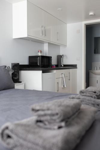 a white room with a bed with towels on it at The snug, Yapton, Arundel, West sussex in Yapton