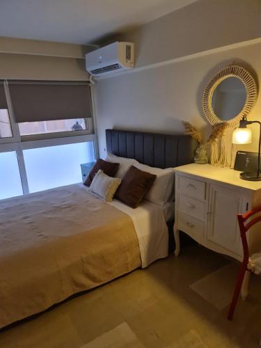 a bedroom with a bed and a desk with a mirror at 48 Central Nest in Volos