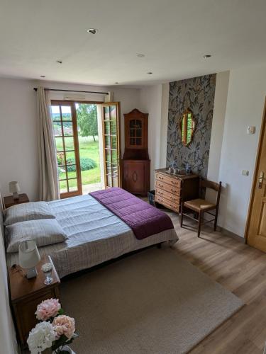 une chambre avec un lit, un bureau et une fenêtre dans l'établissement CYGNE-CYCLES chambre d'hotes, à Fontaine-la-Soret