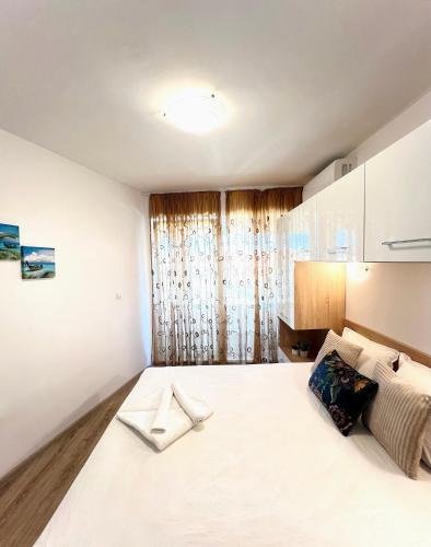 a bedroom with a large white bed in a room at Summer Apart Janet in Obzor
