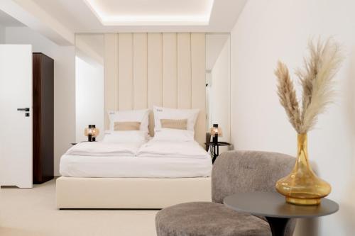 a bedroom with a white bed and a chair at Aqua Bluemica ADULTS ONLY in Międzyzdroje