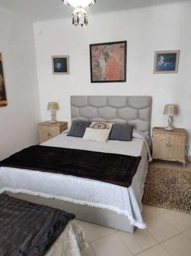a bedroom with a large bed with two night stands at Comfort Beach house in Nazaré