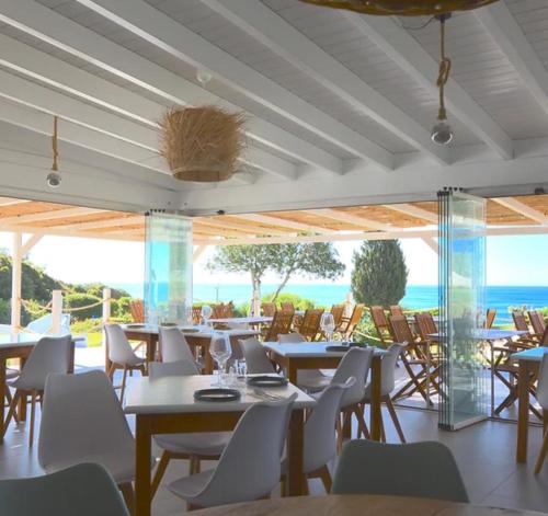 a dining room with tables and chairs and the ocean at 135 Beach Villa in Porches