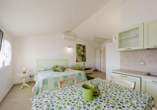 a bedroom with a bed and a table and a kitchen at Agriturismo Le Girandole in Diano Marina