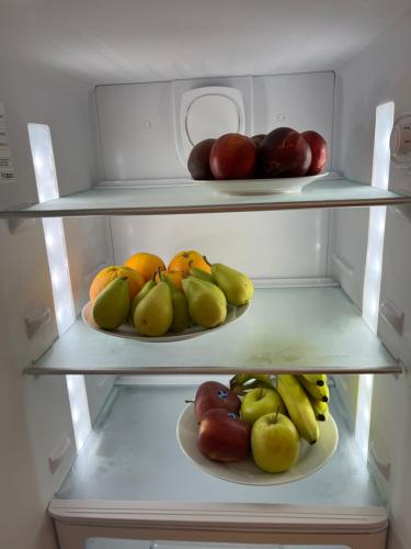 a refrigerator filled with lots of fresh fruit on plates at Ortigia_corte d'avolio in Siracusa