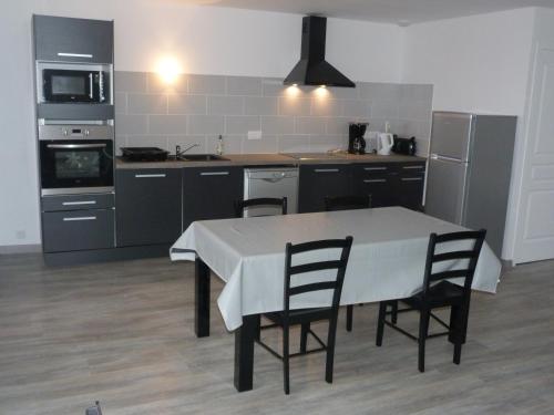 a kitchen with a white table and chairs in it at Oustal haut in Belcastel