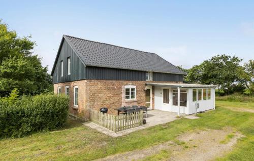 a brick house with a black roof at 3 Bedroom Nice Home In Skærbæk in Skærbæk