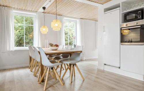 a dining room with a wooden table and chairs at 3 Bedroom Nice Home In Skærbæk in Skærbæk