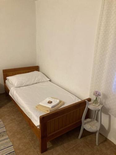 a bedroom with a bed with a table and a chair at Vila Klara room - garden view in Olib