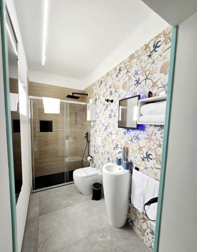a bathroom with a sink and a toilet in it at Aquamarina Rooms in Porto Cesareo