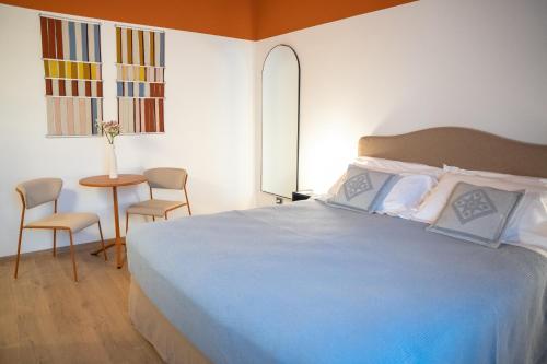 a bedroom with a bed and a table with chairs at Sella&Mosca Casa Villamarina in Alghero