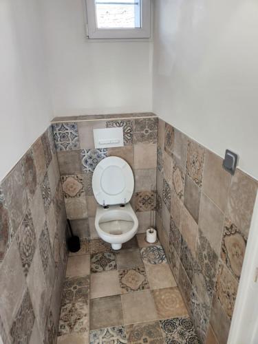une salle de bain avec toilettes dans une pièce carrelée dans l'établissement T3 Cosy, à Saint-Étienne