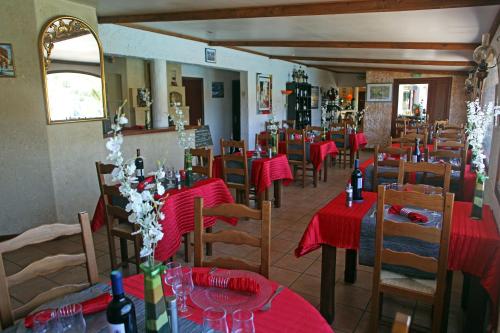 a restaurant with tables and chairs with red table cloth at Logis Hôtel LE PRESSOIR in Saint-Chinian