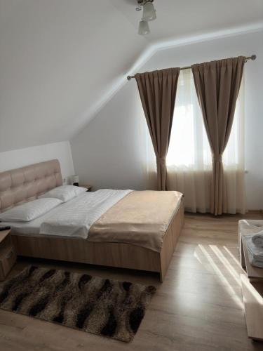 a bedroom with a large bed and a window at Casa Coman Moisei in Moisei