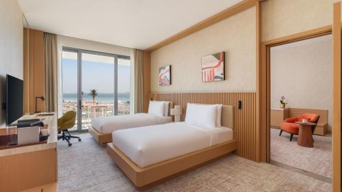 a hotel room with two beds and a television at Rixos Premium Qetaifan Island North in Doha