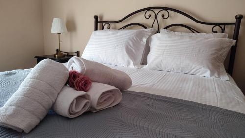 Medusa Myrina Luxury Apartments 1st Floor في ميرينا: سرير عليه مناشف ومخدات