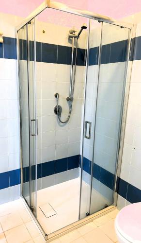 a shower in a bathroom with blue and white tiles at Casa in centro a due passi dal mare in Santa Teresa Gallura