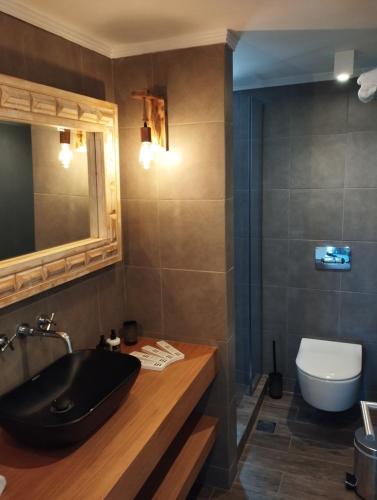 a bathroom with a black sink and a toilet at Costa Meganisi in Meganisi