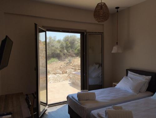 a bedroom with a bed and a sliding glass door at Costa Meganisi in Meganisi