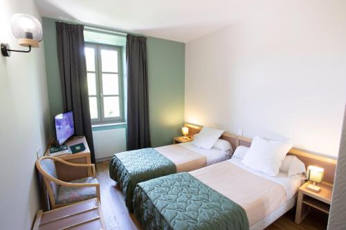 a hotel room with two beds and a chair at Logis Hôtels - Hostellerie des Lauriers - Hôtel et Restaurant in Alban