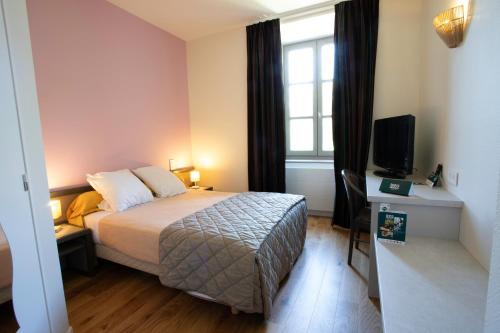 a hotel room with a bed and a television at Logis Hôtels - Hostellerie des Lauriers - Hôtel et Restaurant in Alban
