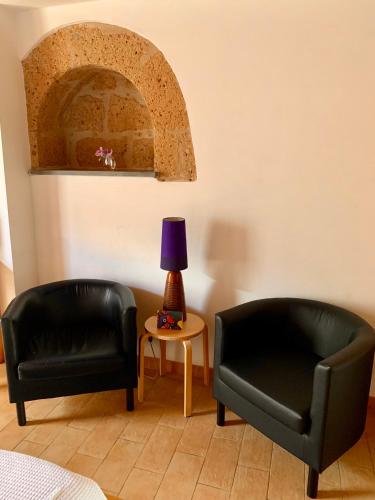two black chairs and a lamp in a room at B&B La Casa Di Tufo in Orvieto