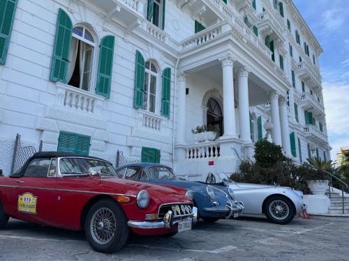 two cars parked in front of a white building at Grand Hotel & des Anglais Spa in Sanremo