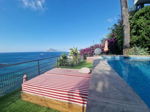a swimming pool with a bed and the ocean at Condesa del Mar adults only in Altea