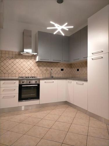 a kitchen with white cabinets and a ceiling fan at La casa smart zona stadio in Terni