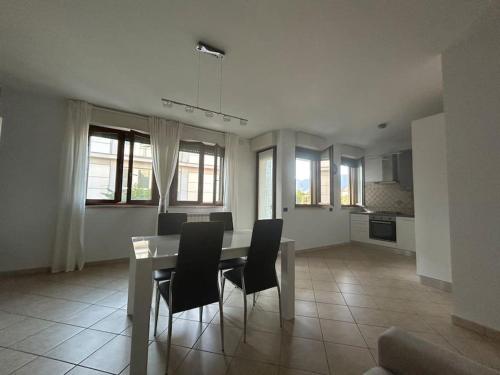 a dining room and living room with a table and chairs at La casa smart zona stadio in Terni