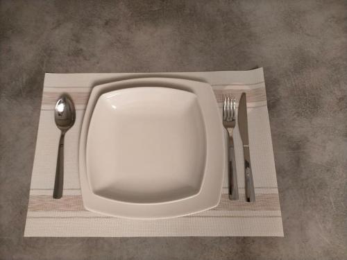 a white plate and fork and knife on a table at La casa smart zona stadio in Terni