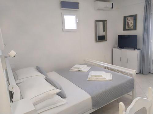a white room with a bed and a television at Apartments Edo in Vis