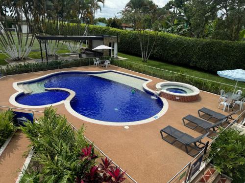 a large swimming pool with chairs and a table at Chalet La Alemania in Calarcá