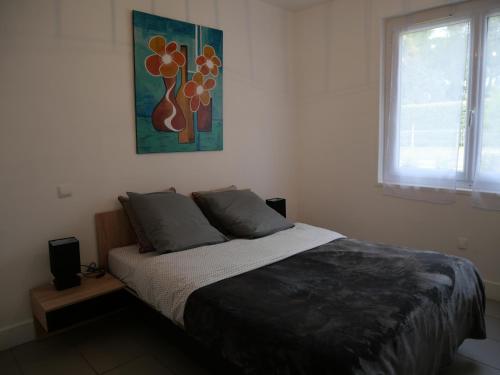 a bedroom with a bed and a painting on the wall at Les Bruyères - Maison in Léon