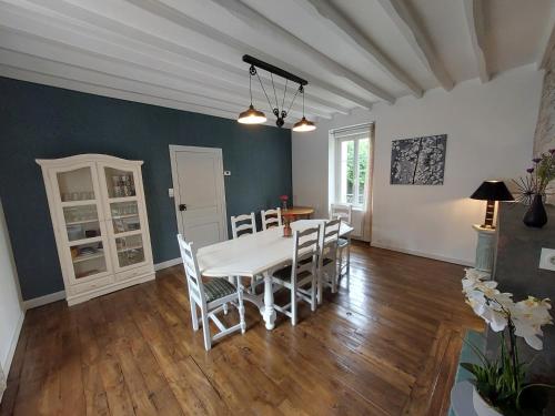une salle à manger avec une table et des chaises blanches dans l'établissement Gîte de la Vallée du Don, à Guéméné-Penfao