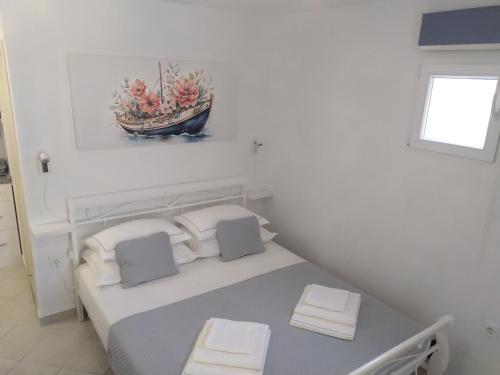 a white room with a bed with a boat on the wall at Apartments Edo in Vis