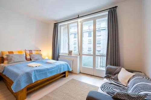 Un dormitorio con una cama y una ventana grande. en Designer Vintage Home near Castle District, en Budapest