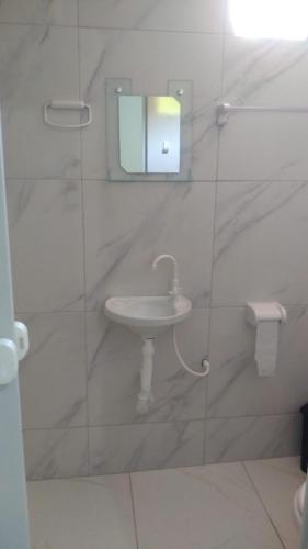 a white bathroom with a sink and a mirror at Jangaloa in Jijoca de Jericoacoara