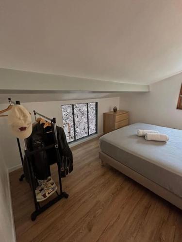une chambre avec un lit et un parquet dans l'établissement L'Esmeralda - Maisonnette de vacances, à Villeneuve-Loubet