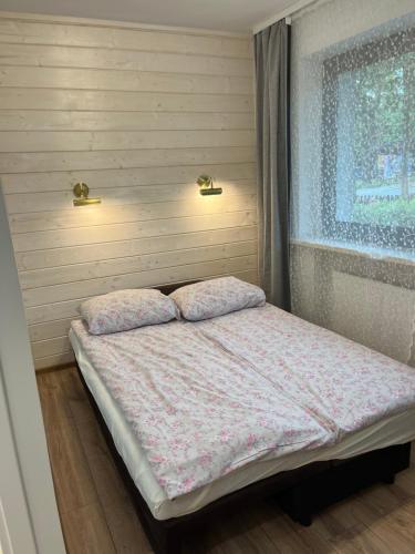 a small bedroom with a bed and a window at Dwunastka in Zakopane