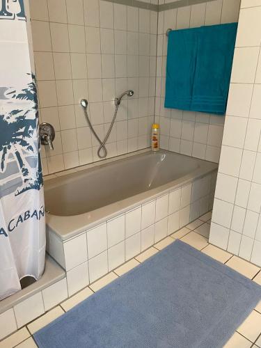 a bath tub in a bathroom with a blue rug at Ferienwohnung Steinhoff in Nordkirchen