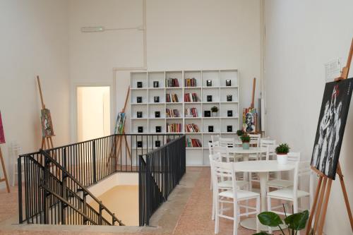 a room with a table and a book shelf at HUB Portanova in Trani